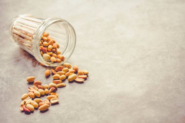 Gri arka planda bir bardakta kavrulmuş fıstık. Sağlıklı lifesty