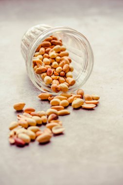 Gri arka planda bir bardakta kavrulmuş fıstık. Sağlıklı lifesty