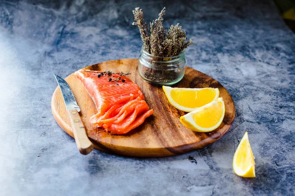 Salted smoked salmon with rosemary on a wooden board. Healthy fo — Stock Photo, Image