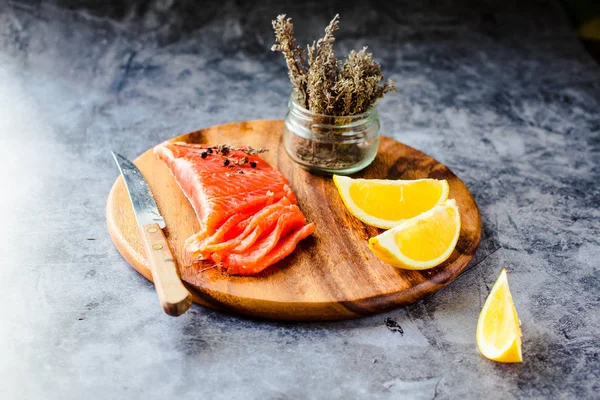 Salted smoked salmon with rosemary on a wooden board. Healthy fo — Stock Photo, Image