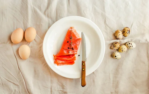 Raw Salt Smoked Salmon steaks with quail eggs on a white linen t — Stock Photo, Image