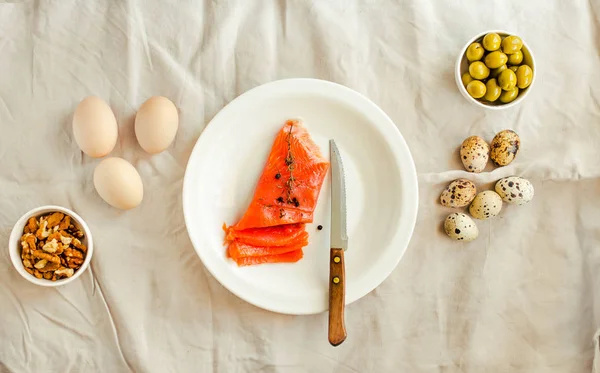 Sal Salmom con huevos de codorniz, nueces y aceituna en una lengüeta de lino blanco — Foto de Stock
