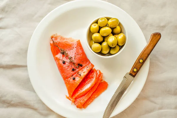 Slices of Salted Raw fish fillet with olive on white plate. Prod — Stock Photo, Image