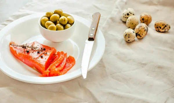 Slices of Salted Raw fish fillet with olive, quail eggs on white — Stock Photo, Image