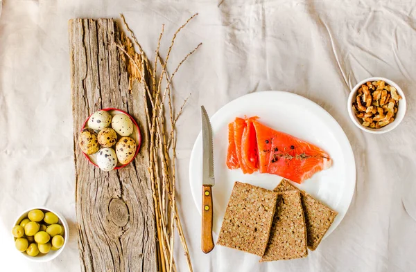 Filete de salmón de pescado salado con oliva, huevos de codorniz, nueces y pan —  Fotos de Stock