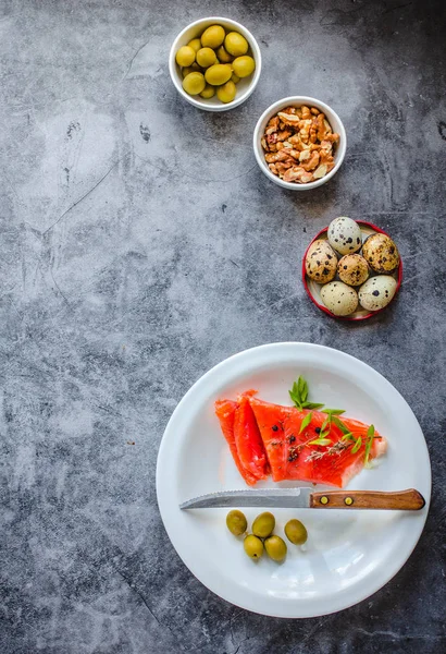 Salmón de pescado rojo ahumado con aceitunas, huevos de codorniz, frutos secos y arroz crudo — Foto de Stock