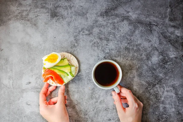 Vue du dessus de la jeune femme qui fait une pause déjeuner. Gâteaux croustillants au riz — Photo