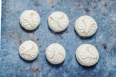 Mavi metal arka planda beyaz marşmelov ve kahve.