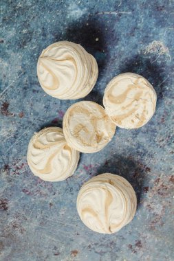 Mavi metal arka planda beyaz marşmelov ve kahve.