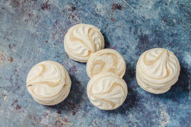 Mavi metal arka planda beyaz marşmelov ve kahve.