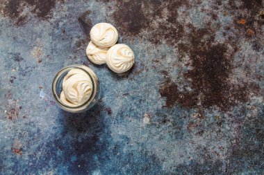 Mavi metal arka planda beyaz marşmelov ve kahve.