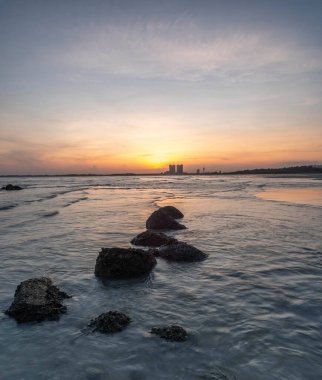 Sahilde kayaların oluşumunun gün batımı manzarası. Gökyüzünde güzel renkler var.