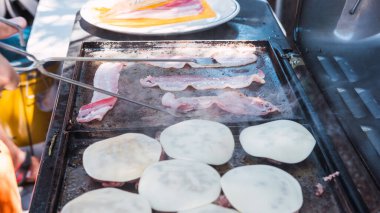 Izgaranın üstünde domuz pastırması ve çizburger.