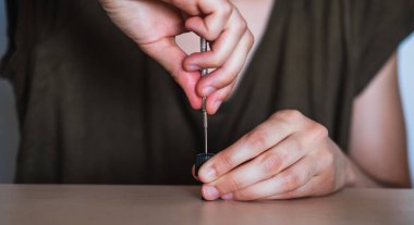 Tornavida kullanan bir kadının elleri.