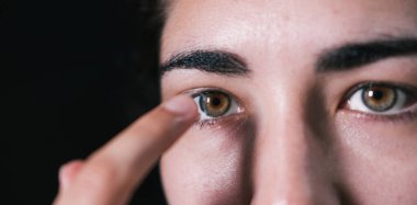 Kadın gözüne kontak lens takıyor.