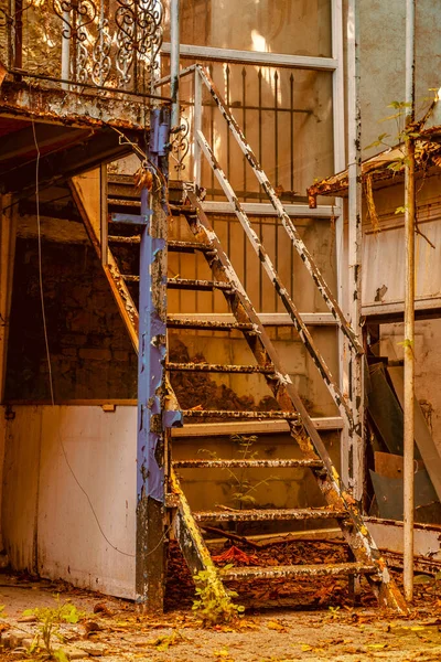 Terk edilmiş bir yerde çok eski, köhne demir merdivenler, dramatik bir bakımsızlık sahnesi, yakın çekim..