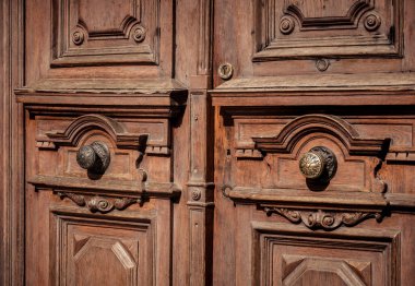 Çok eski bir antika görünümlü ahşap kapılar, kapalı kahverengi ahşap kapılar, caddeye bakan güneş ışığı altında. 