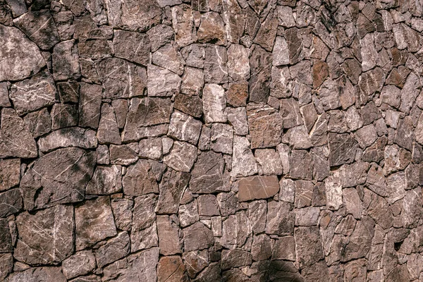 Granit kayalardan yapılmış bir duvar, duvar arkası. gri ve kahverengi tonlar. 