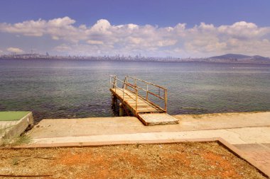 Eski paslı metal rıhtımın mavi gökyüzü ve bulutlarla panoramik görüntüsü. Yemin olsun, (iyiliklerle) birleşen şehre,.