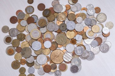 Dünyanın dört bir yanından bozuk para koleksiyonunun kuş bakışı görüntüsü, birçok farklı ülkenin sembolleri.