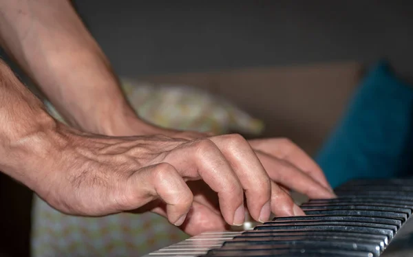 Piyano çalan bir adam, sadece eller. Aşırı yakın çekim.