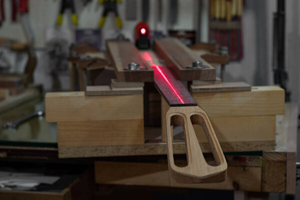 a scene of neck straight level control and assembly with red laser in an instrument making workshop
