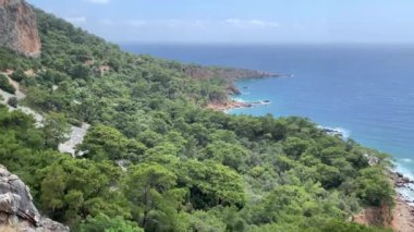 Güneşli bir günde Akdeniz 'in, dağların ve çam ağaçlarının olduğu vahşi sahillerin manzarası. 4k video.