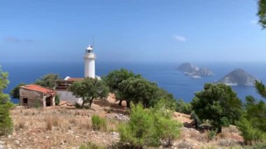 Antalya Türkiye 'deki ünlü Gelidonia (Gelidonya) Deniz feneri zeytin ve çam ağaçlarıyla çevrili. Arka planda Akdeniz ve adalar. 4k stok video. 