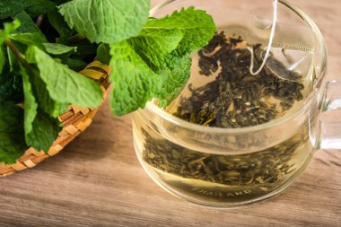 Cam fincan nane çayı ile taze nane yaprakları yeşil, gevşeme ve sağlıklı içecek kadar kapatın