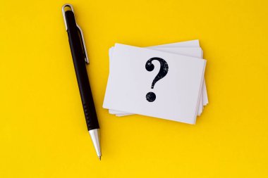 canlı sarı arka plan, sorular ve cevaplar veya Q&A üzerinde yazılı soru işareti simgesi olan beyaz bir kartvizit istifleme konsept tasarımı