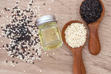 organik siyah ve Beyaz Susam tahta kaşıkla petrol şişe, üstten görünüm veya havai çekim içinde