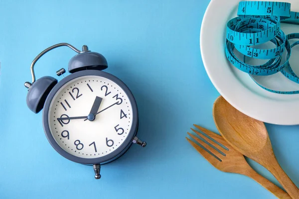 Time to lose weight , eating control or time to diet concept , alarm clock with healthy tool concept decoration on blue background