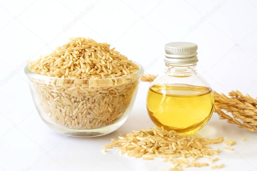 Close up brown rice seed and rice bran oil in bottle  and unmilled rice on white background , good fats for healthy food