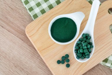 Spirulina tozu kaşık, sağlıklı superfood diyet tabağı ve spirulina hap kadar kapatın ve detoks beslenme kavramı