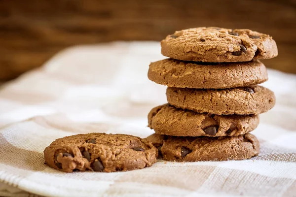 Close up stacked chocolate chip cookies on  napkin with wooden b — Stock Photo, Image
