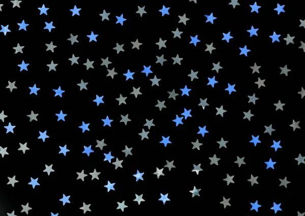 Blue and silver stars glitter on a black isolated background.