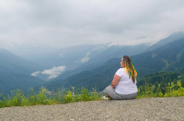 Young woman with braids in the mountains on a clear day