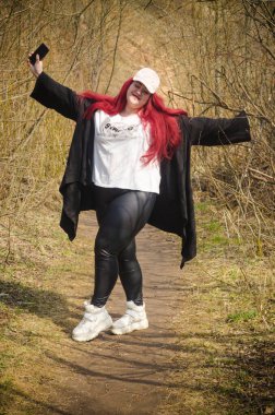 Tombul bir kız kolları açık durur.