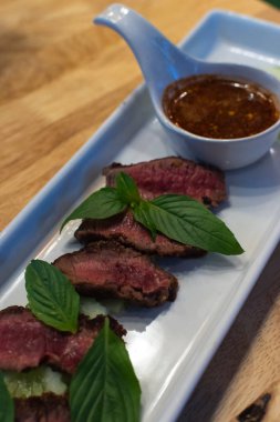 Sığır eti Orta nadir ve onun Tay baharatlı dipsauce ile hizmet eden, pişmiş.