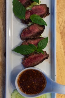 Sığır eti Orta nadir ve onun Tay baharatlı dipsauce ile hizmet eden, pişmiş.