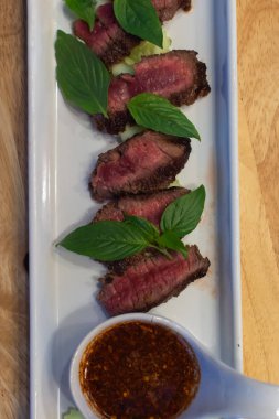 Sığır eti Orta nadir ve onun Tay baharatlı dipsauce ile hizmet eden, pişmiş.