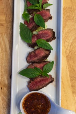 Sığır eti Orta nadir ve onun Tay baharatlı dipsauce ile hizmet eden, pişmiş.