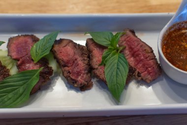 Sığır eti Orta nadir ve onun Tay baharatlı dipsauce ile hizmet eden, pişmiş.