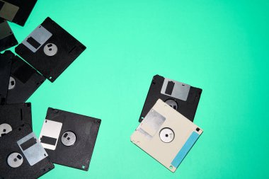 Stüdyonun mavi arka planına yerleştirilmiş eski siyah beyaz disketlerin genel görünümü