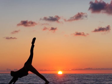 Pratik yoga arka plan günbatımı ve okyanus kız.