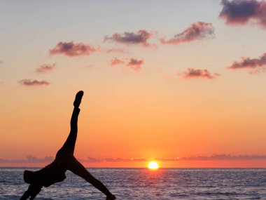 Pratik yoga arka plan günbatımı ve okyanus kız.