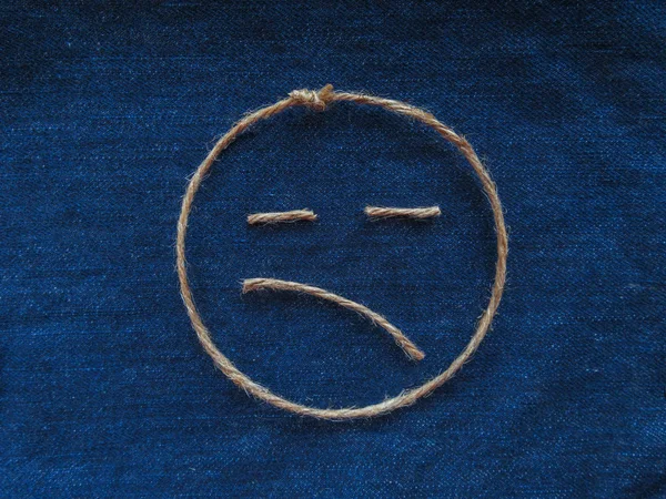 Smutną twarz sznurka w denim. Emoji — Zdjęcie stockowe