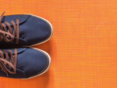 Turuncu zemin üzerine mavi spor ayakkabı