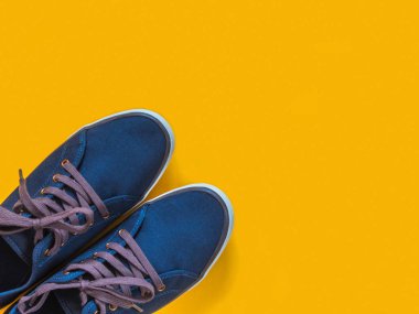Sarı zemin üzerine mavi spor ayakkabı