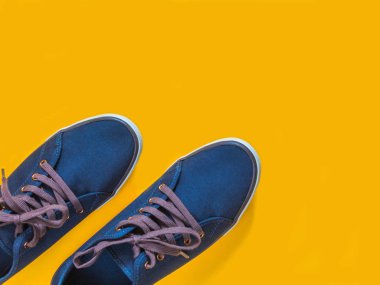 Sarı zemin üzerine mavi spor ayakkabı